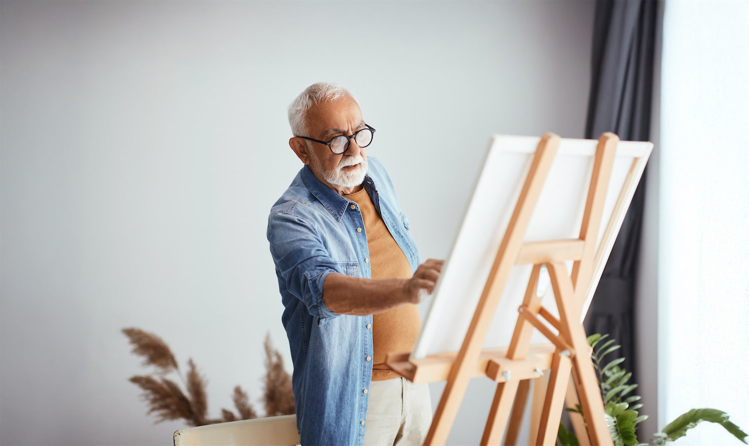 elderly man painting on a canvas